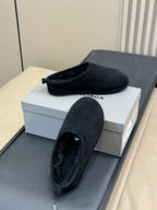 Black suede slip-on sandal with plush interior and textured sole