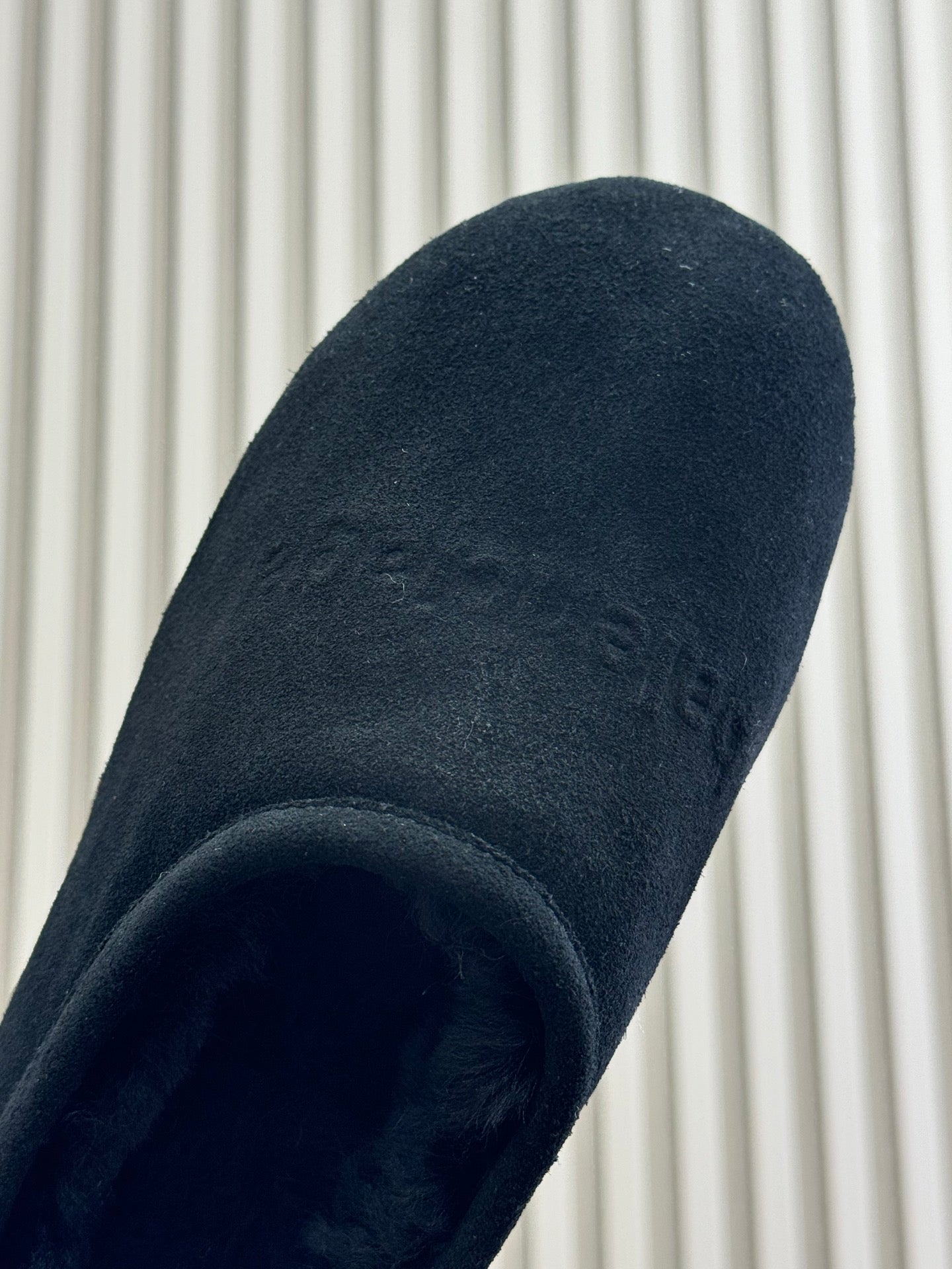 Black suede upper close-up with rounded cuff opening