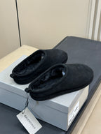 Black suede slip-on mules with plush lining and tag attached