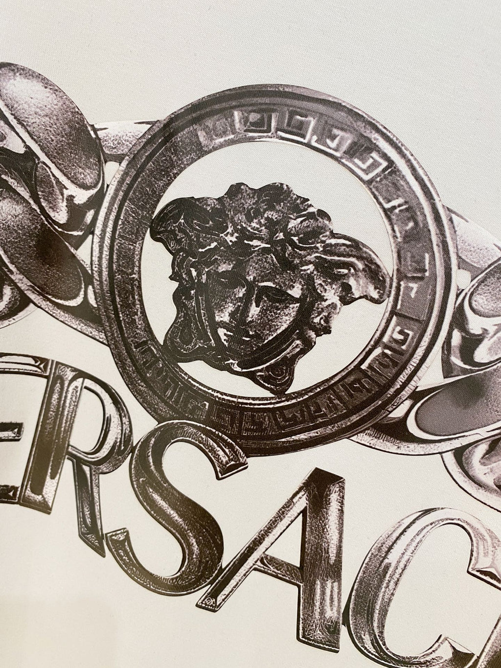 White Versace logo T-shirt close-up of lion crest and metallic print