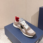 Dior unisex sneaker with beige suede panels, white laces, black accent, and red collar lining