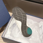 Unisex sneaker outsole in box, dark tread with white midsole and teal heel insert