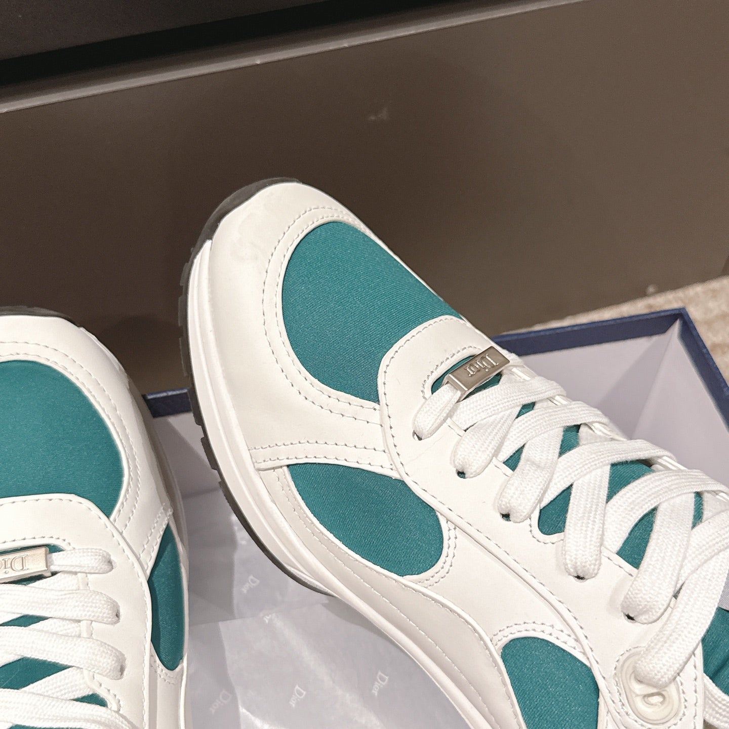 Unisex sneaker profile, white leather with teal oval insert and lace-up closure