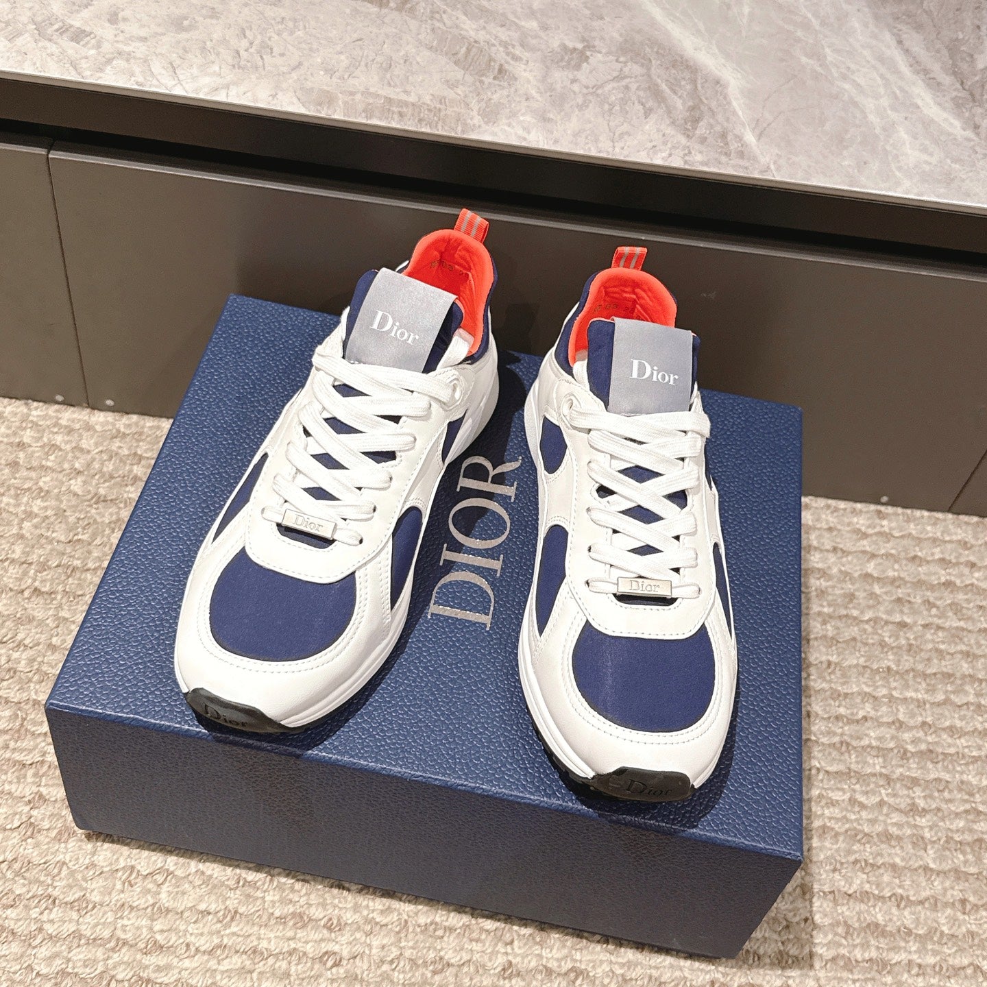 Dior unisex sneakers in white and navy with orange-red tongue and lace panels