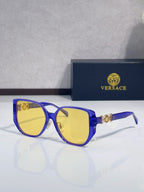 Bright blue sunglasses with rounded yellow lenses and gold logo detail on temples
