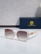 Light pink sunglasses with rounded lenses and gold logo detail on temples