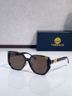 Tortoiseshell sunglasses with rounded dark lenses and gold logo detail on temples