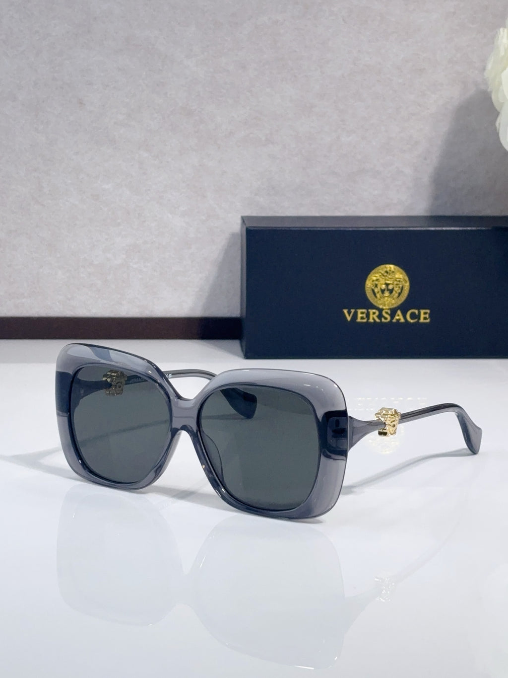 Versace sunglasses with dark blue frames and smoked gray-tinted lenses