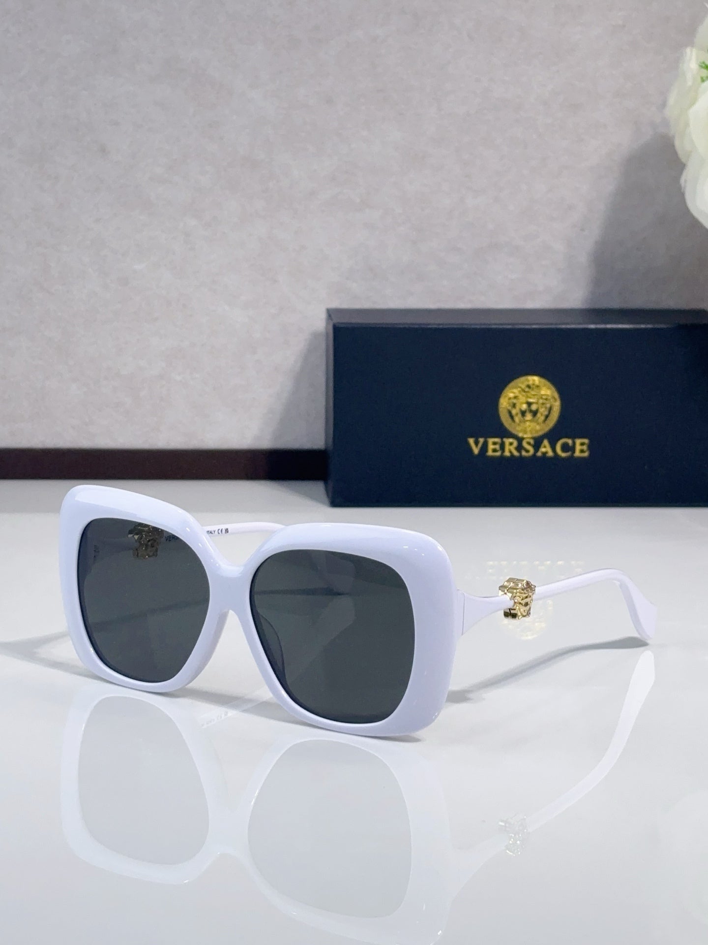 Versace sunglasses with white frames and dark gray-tinted lenses