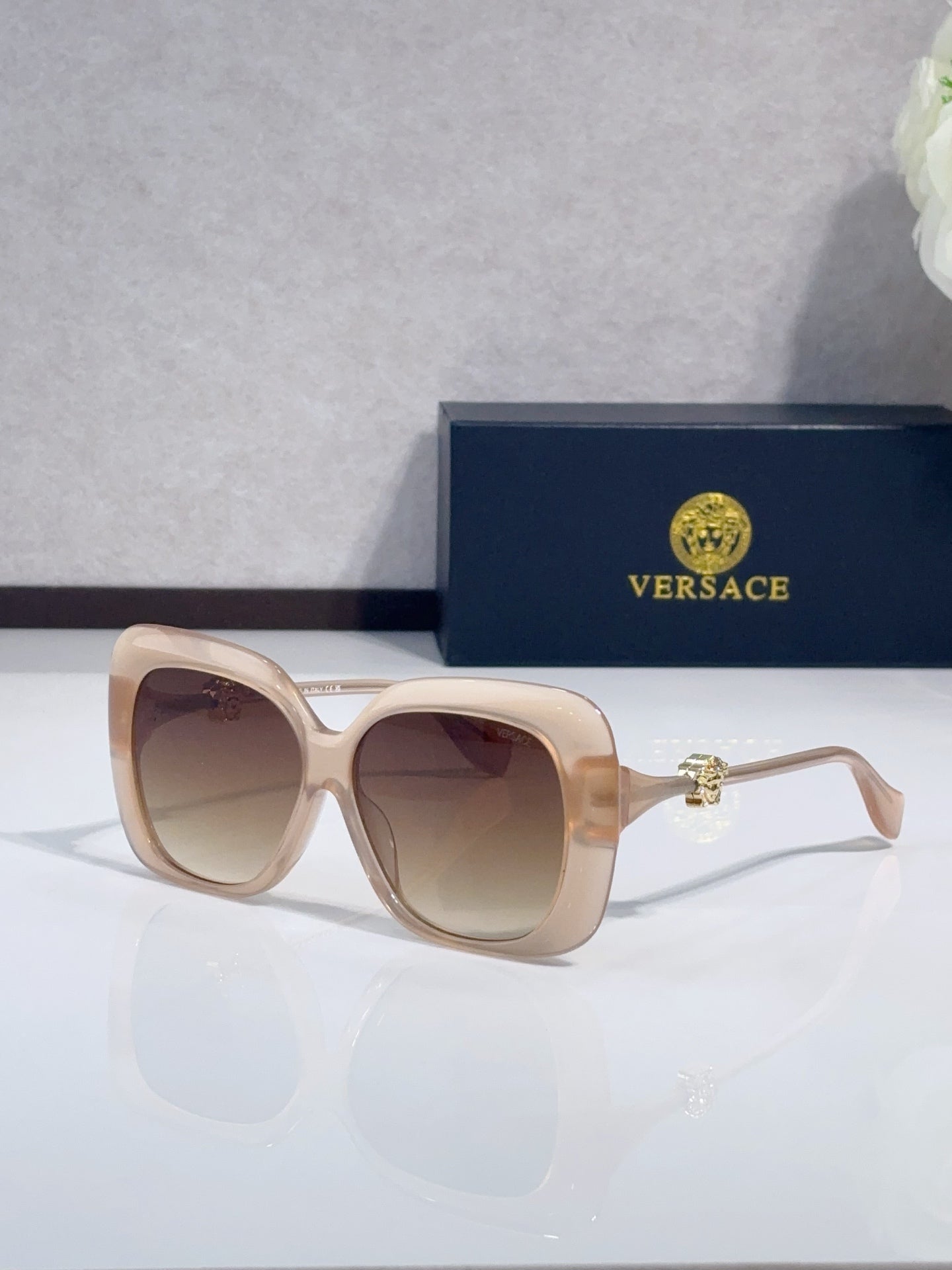Versace sunglasses with beige frames and brown-tinted lenses