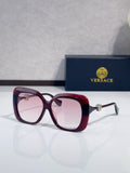 Versace sunglasses with dark maroon frames and pink-tinted lenses