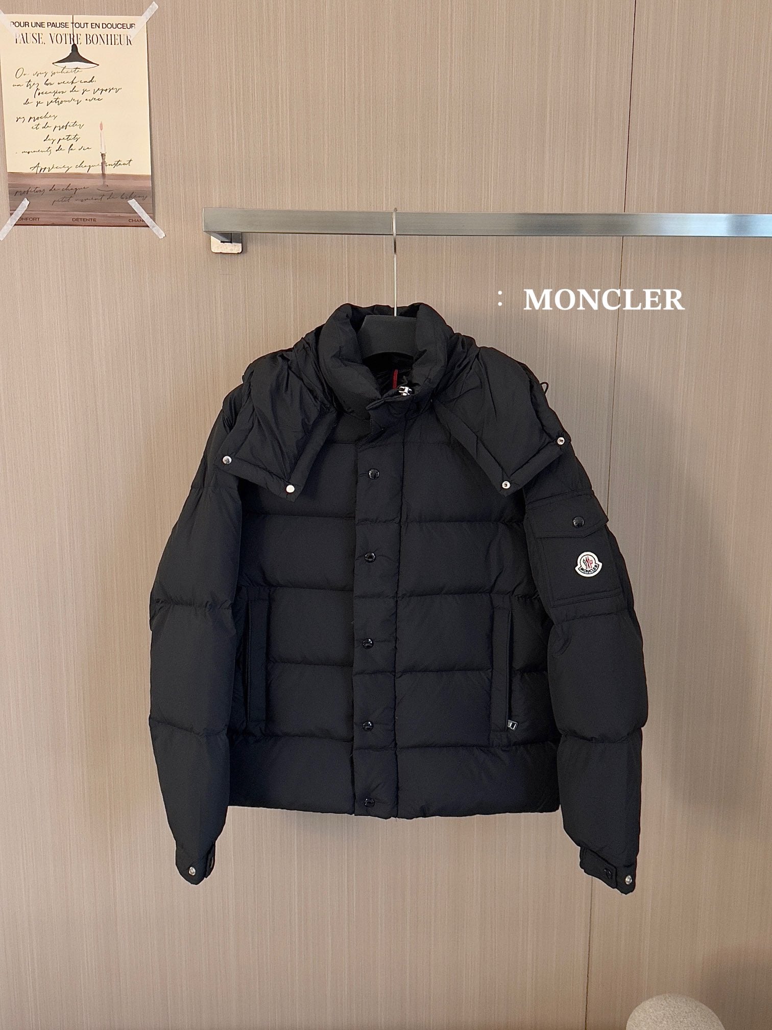 Black puffer jacket with hood, button front and Moncler logo patch on sleeve