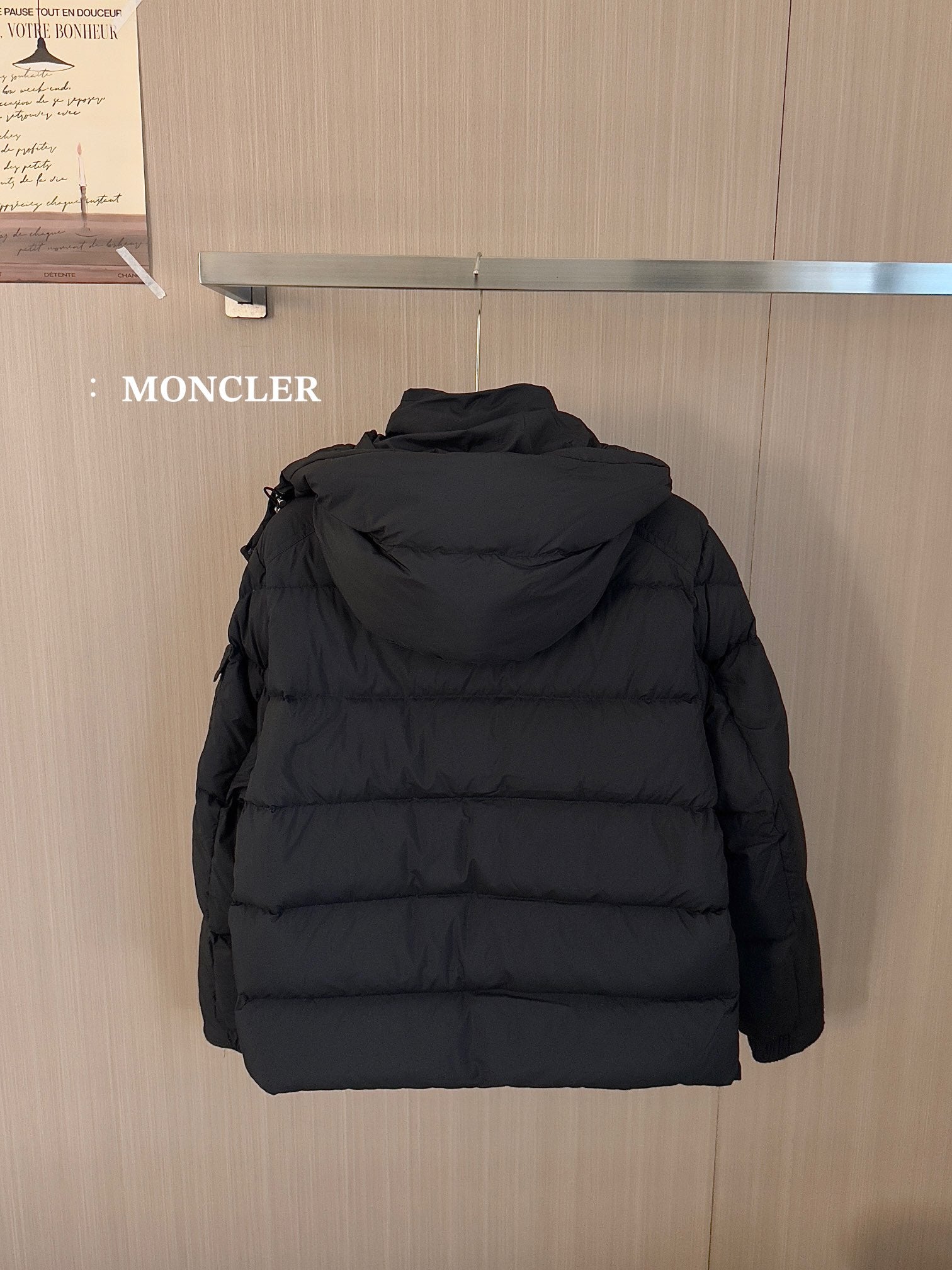 Black puffer jacket back view with hood and stitched quilted panels