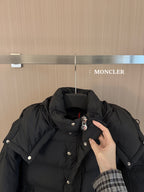 Black puffer jacket collar and hood with snap buttons and small logo pin