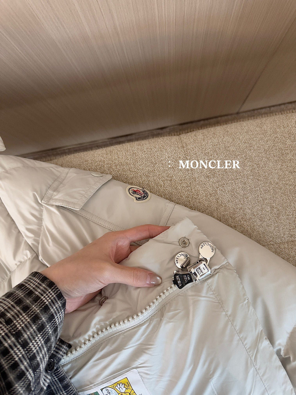 Moncler long white puffer jacket inner label and zipper pull detail on hood lining