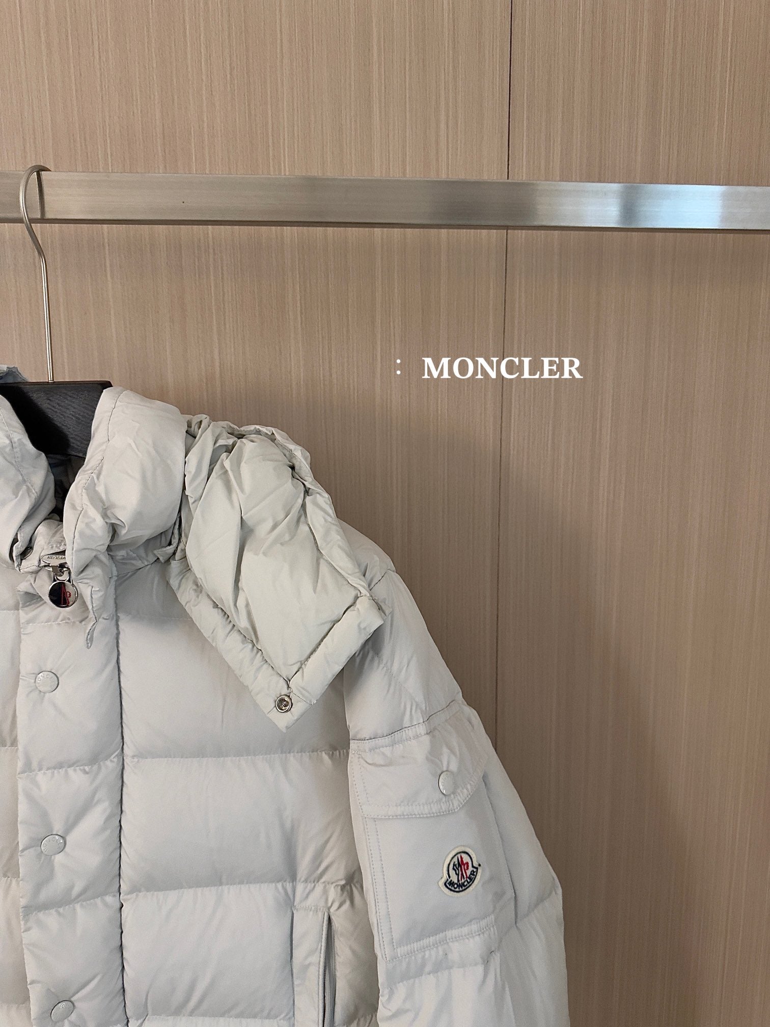 Moncler long white puffer jacket, side view with quilted sections and snap cuffs