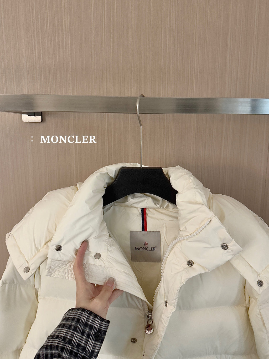 White long puffer jacket, inner hood and label visible, held open by hand