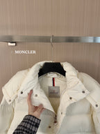 White long puffer jacket, inner hood and label visible, held open by hand