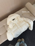 White long puffer jacket on sofa, hooded with quilted padding and button front