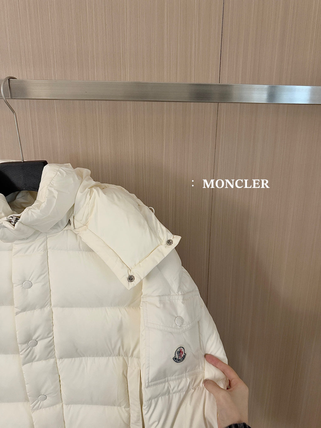 White long puffer jacket, side view with snap buttons and logo patch