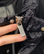 Dior zipper pull and ring hardware on black puffer jacket fabric