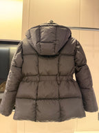 Long dark puffer jacket with hood, back quilting, and cinched waist