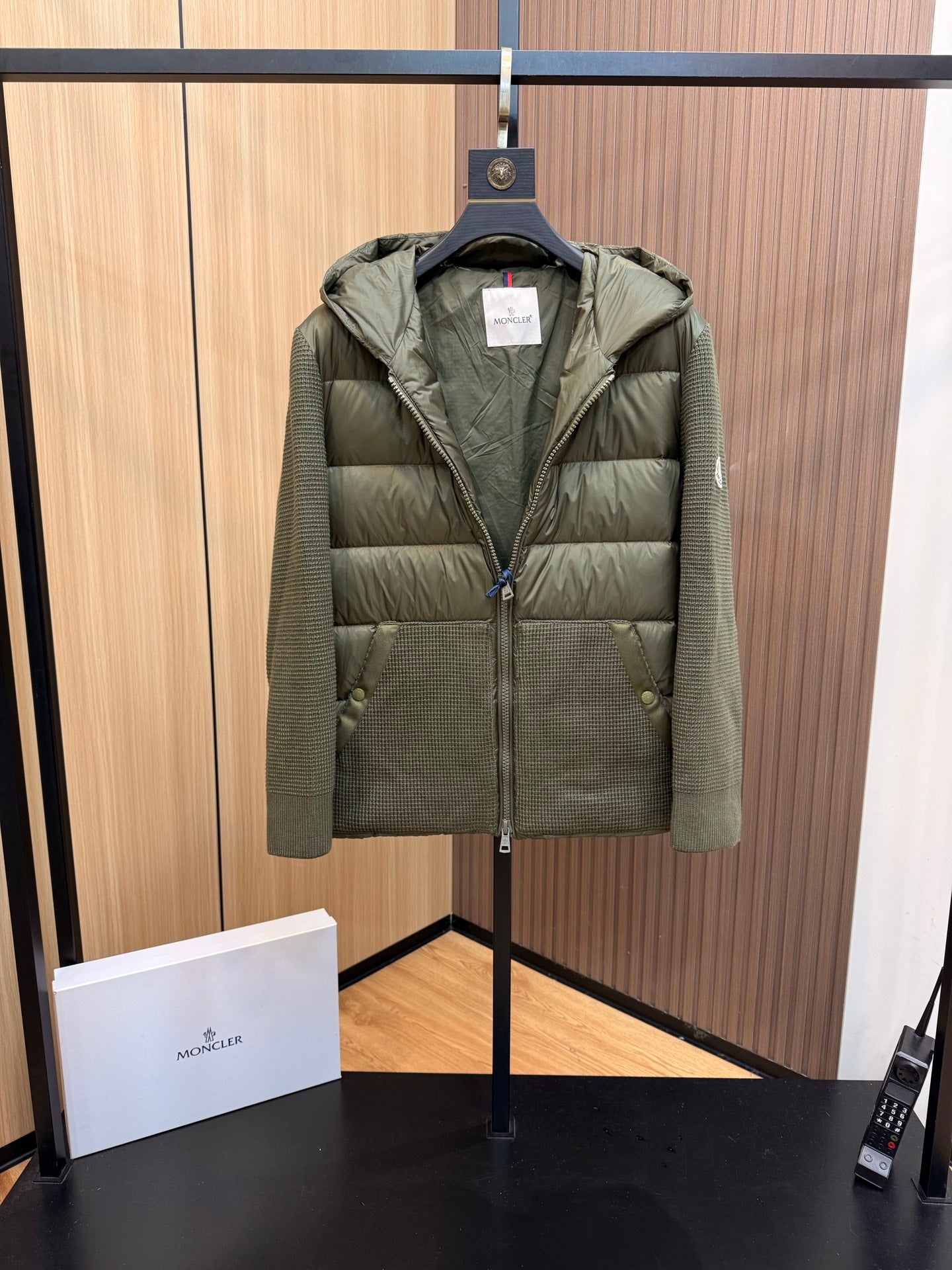 Long puffer jacket in dark olive green, front view with zip and two flap pockets