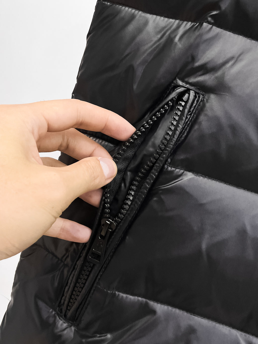 Moncler hooded puffer vest, black front zipper and stitched placket close-up