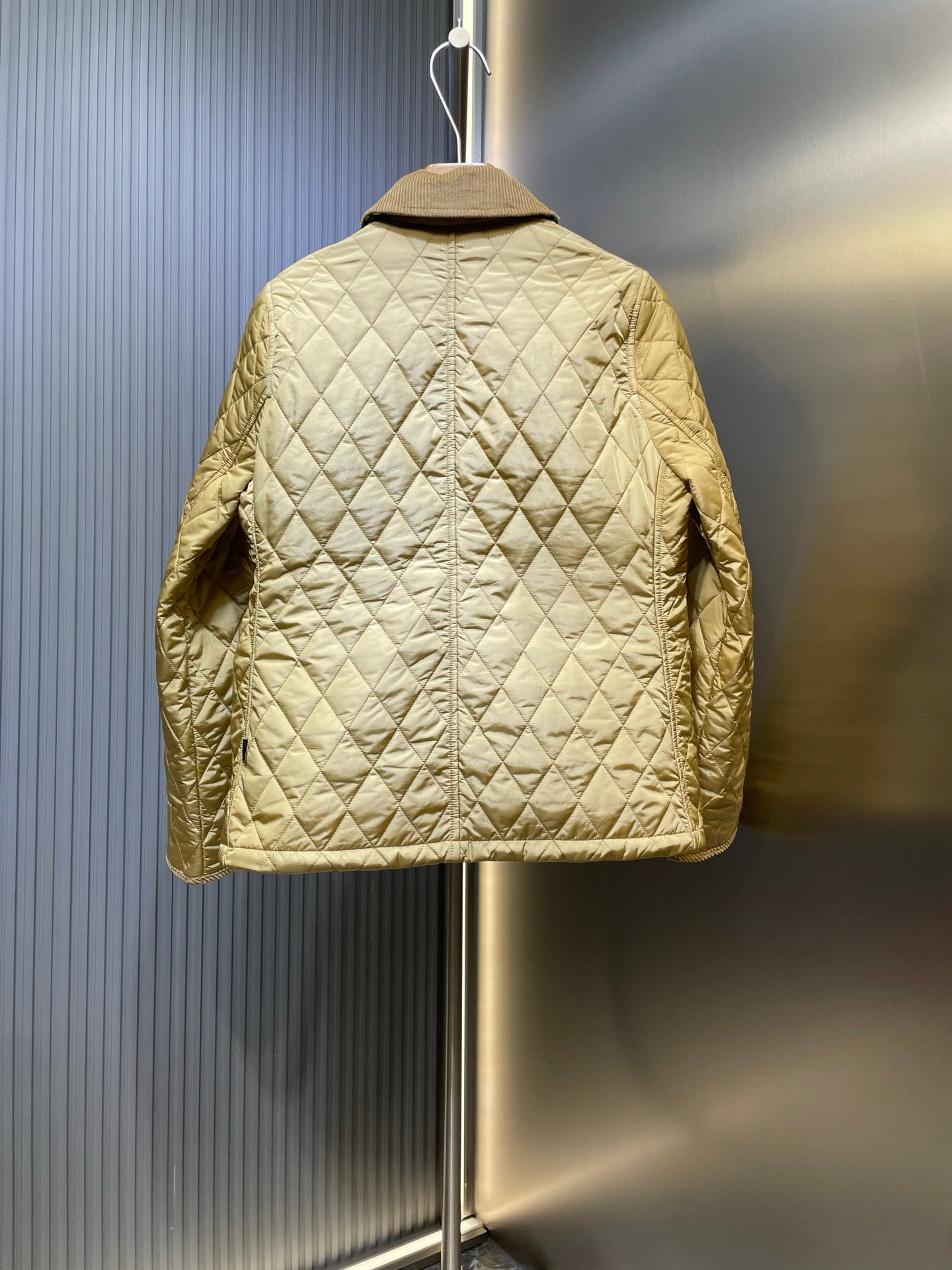 Light yellow quilted jacket with back view, button center seam, and long sleeves
