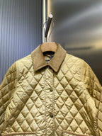 Light yellow quilted jacket with button front, stand collar, and chest pocket detail