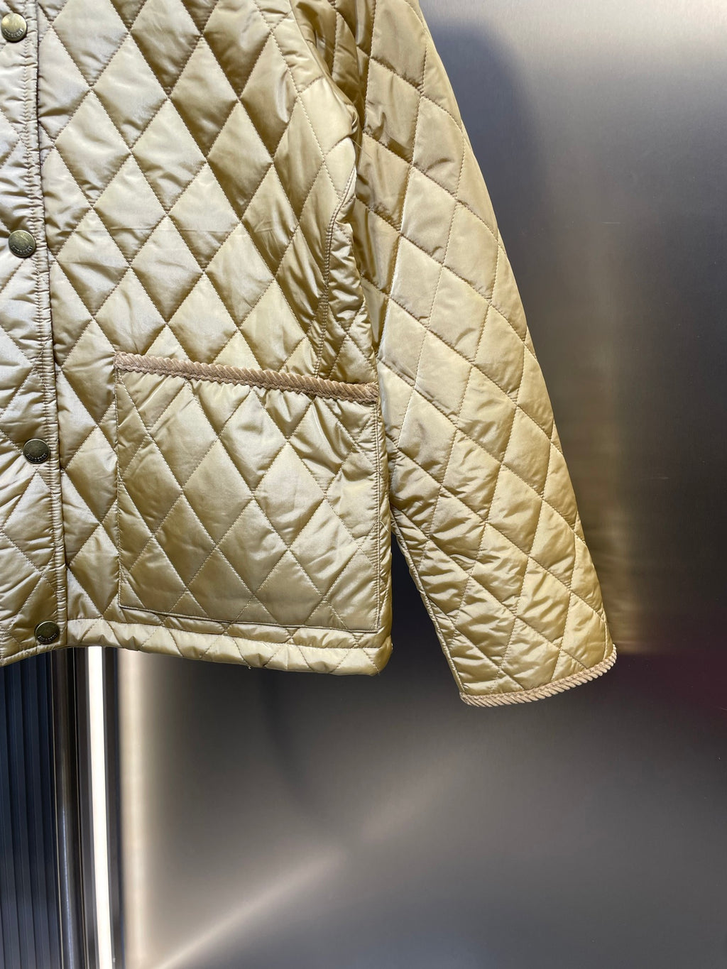 Quilted light yellow jacket with front pocket panel and button trim on sleeve