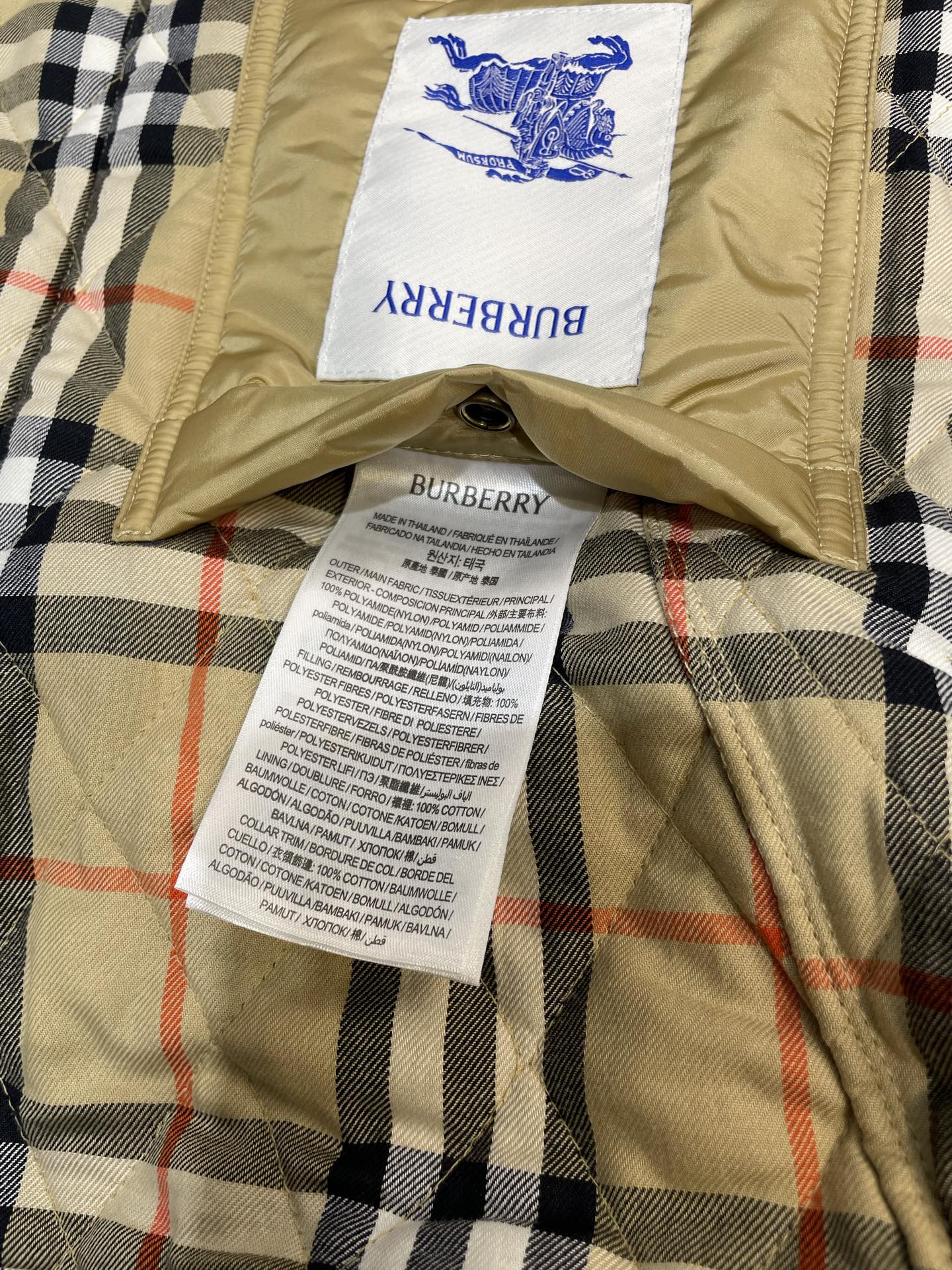 Burberry quilted jacket lining close-up with label and fabric tags on plaid panel