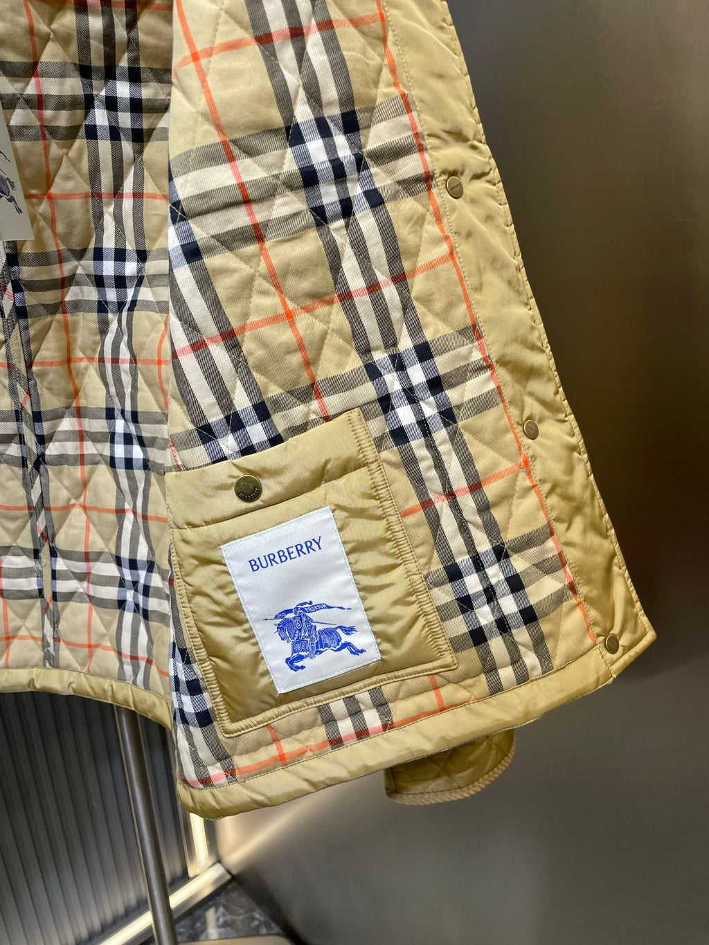 Plaid-lined quilted jacket sleeve cuff with Burberry patch on pocket