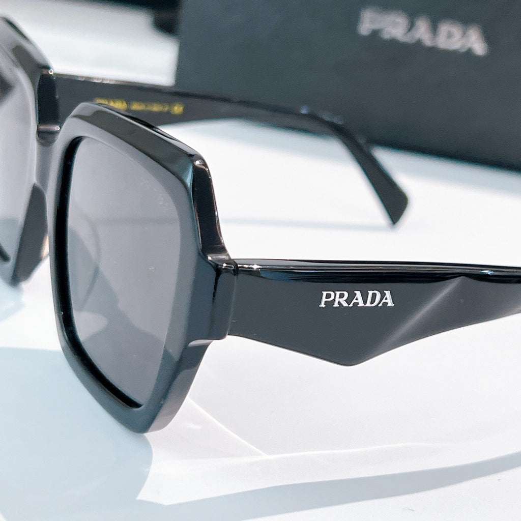 Prada sunglasses black angular frames with dark lenses, side view