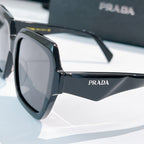 Prada sunglasses black angular frames with dark lenses, side view