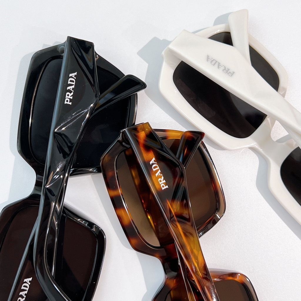 Prada sunglasses set with black and tortoiseshell frames on display