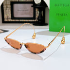 Bottega Veneta cat-eye sunglasses with gold frame and amber tinted lenses