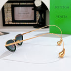 Bottega Veneta cat-eye sunglasses side view with gold frame and dark green lenses