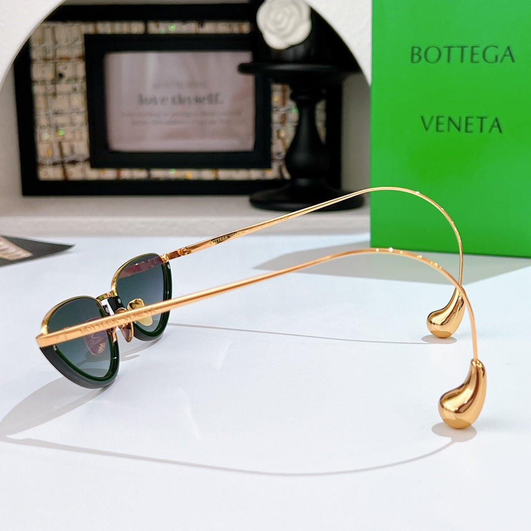 Bottega Veneta cat-eye sunglasses side view with gold frame and dark green lenses
