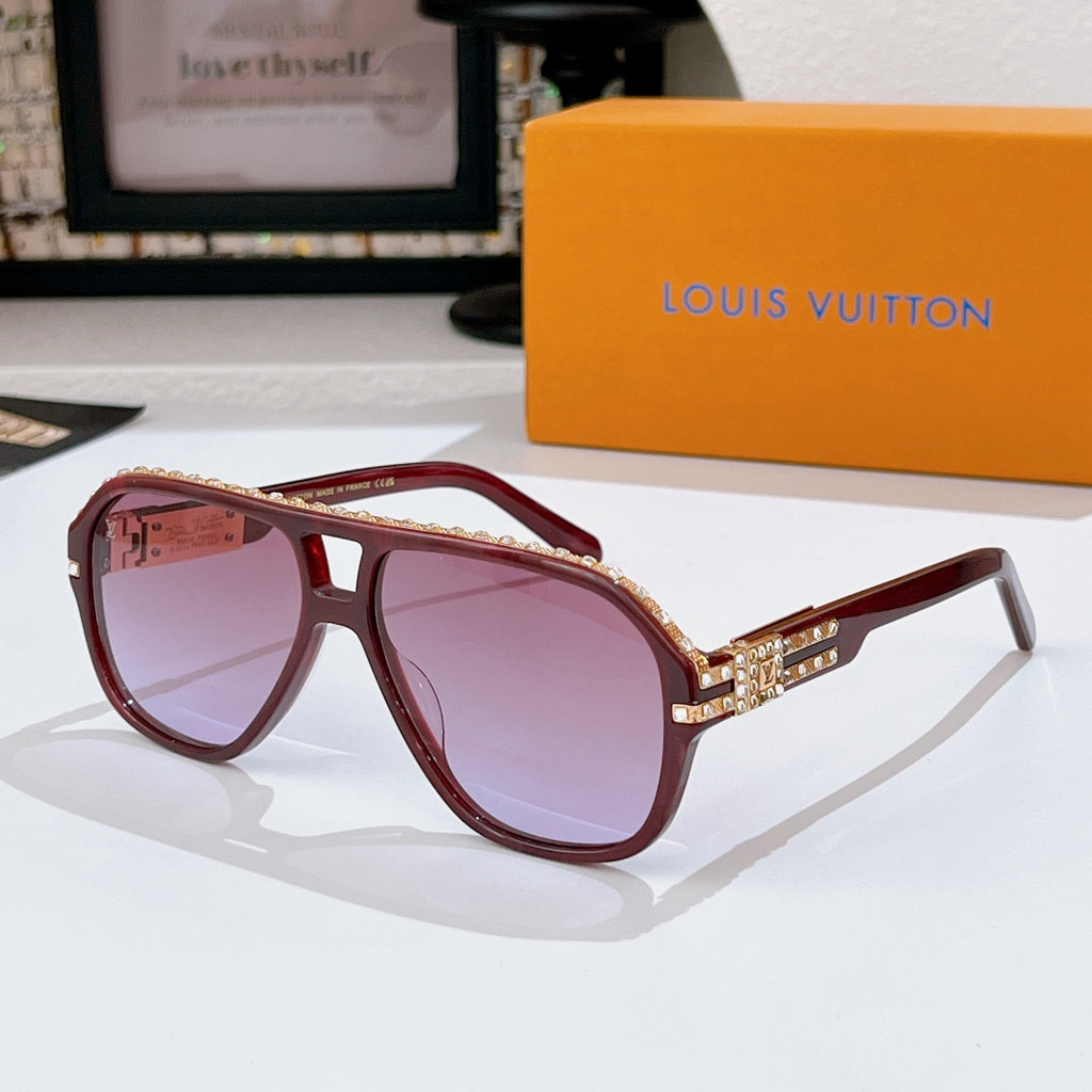 Sunglasses with burgundy frames and tinted lenses; rhinestone logo detail on temples