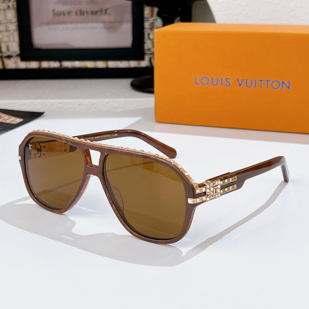 Sunglasses with brown frames and tinted lenses; rhinestone logo detail on temple band