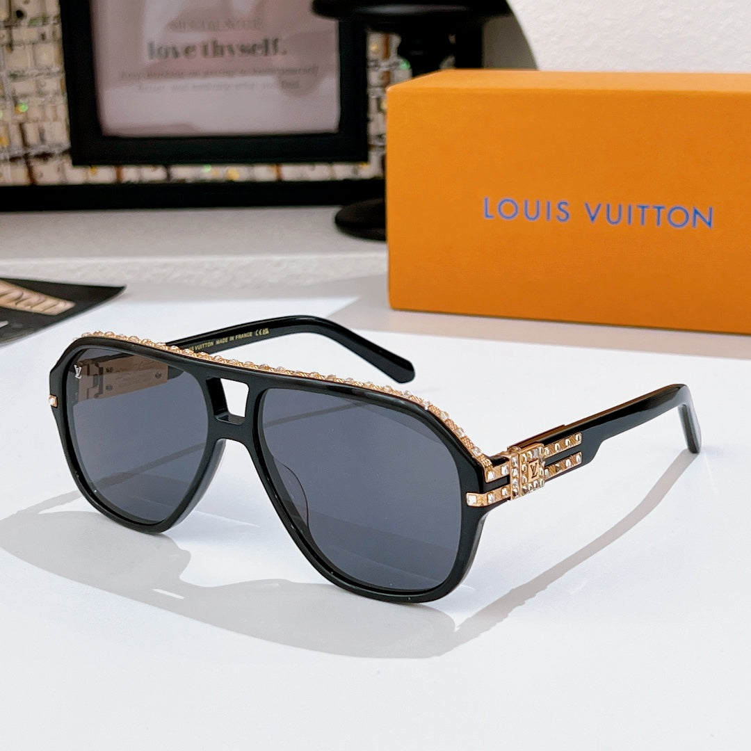 Sunglasses with dark frames and tinted lenses; rhinestone logo detail on temple band