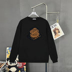 Black Moncler long-sleeve top with circular logo graphic at chest