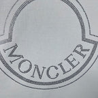 Moncler crest logo on white sweatshirt, dotted with crystal-like studs.