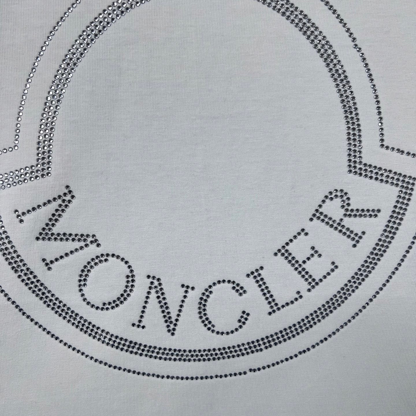 Moncler crest logo on white sweatshirt, dotted with crystal-like studs.
