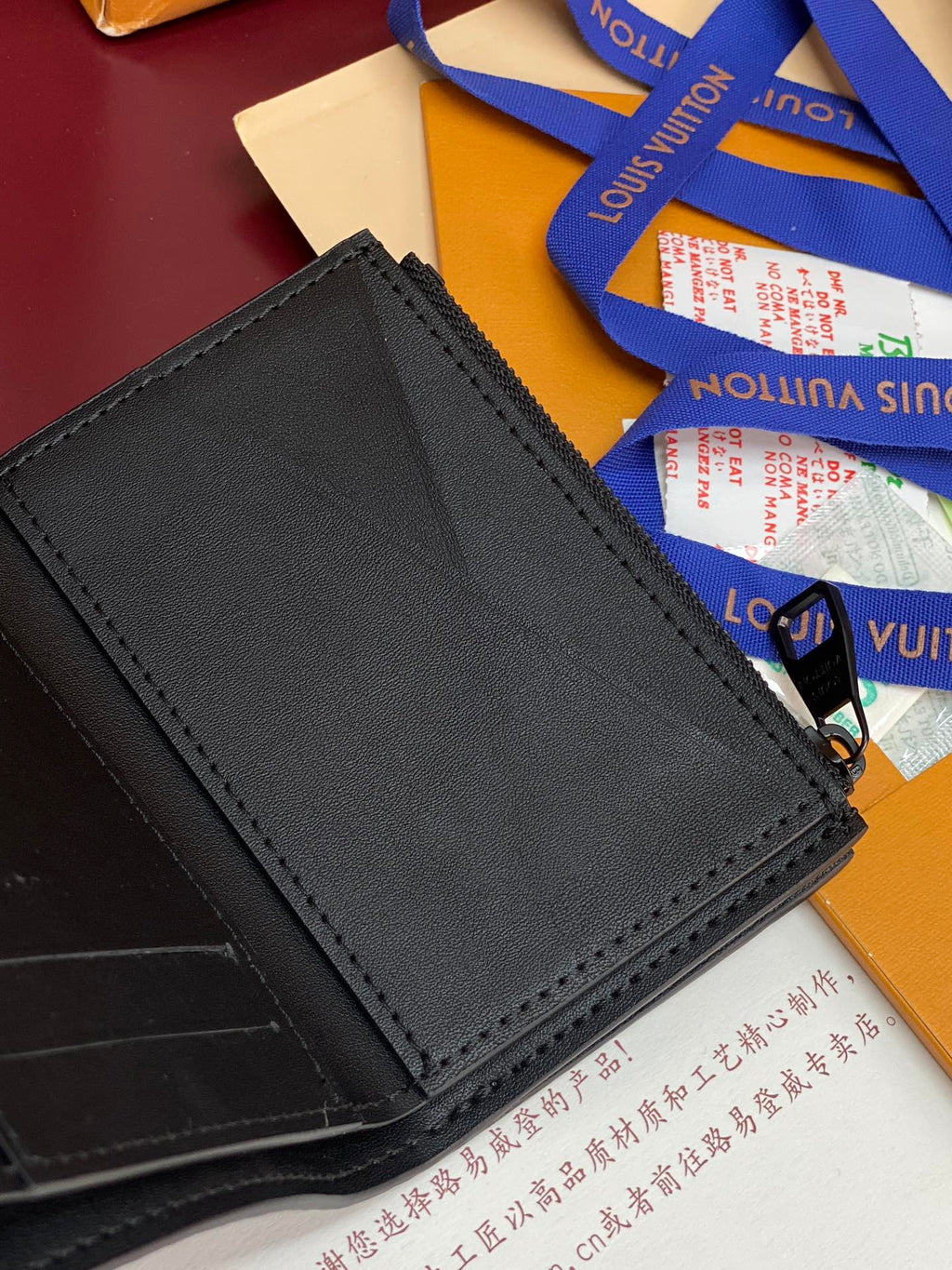 Black textured leather small bag with stitched border and snap closure at front.