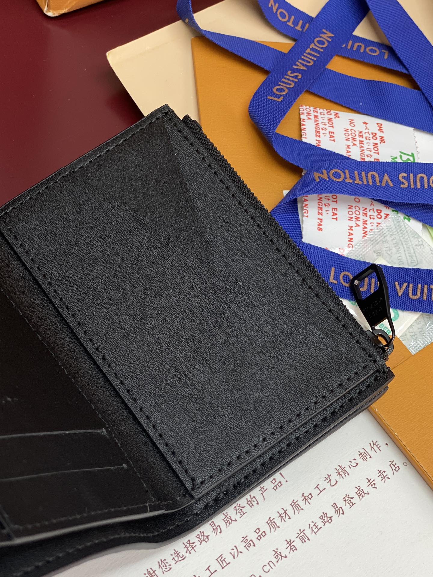 Black textured leather small bag with stitched border and snap closure at front.