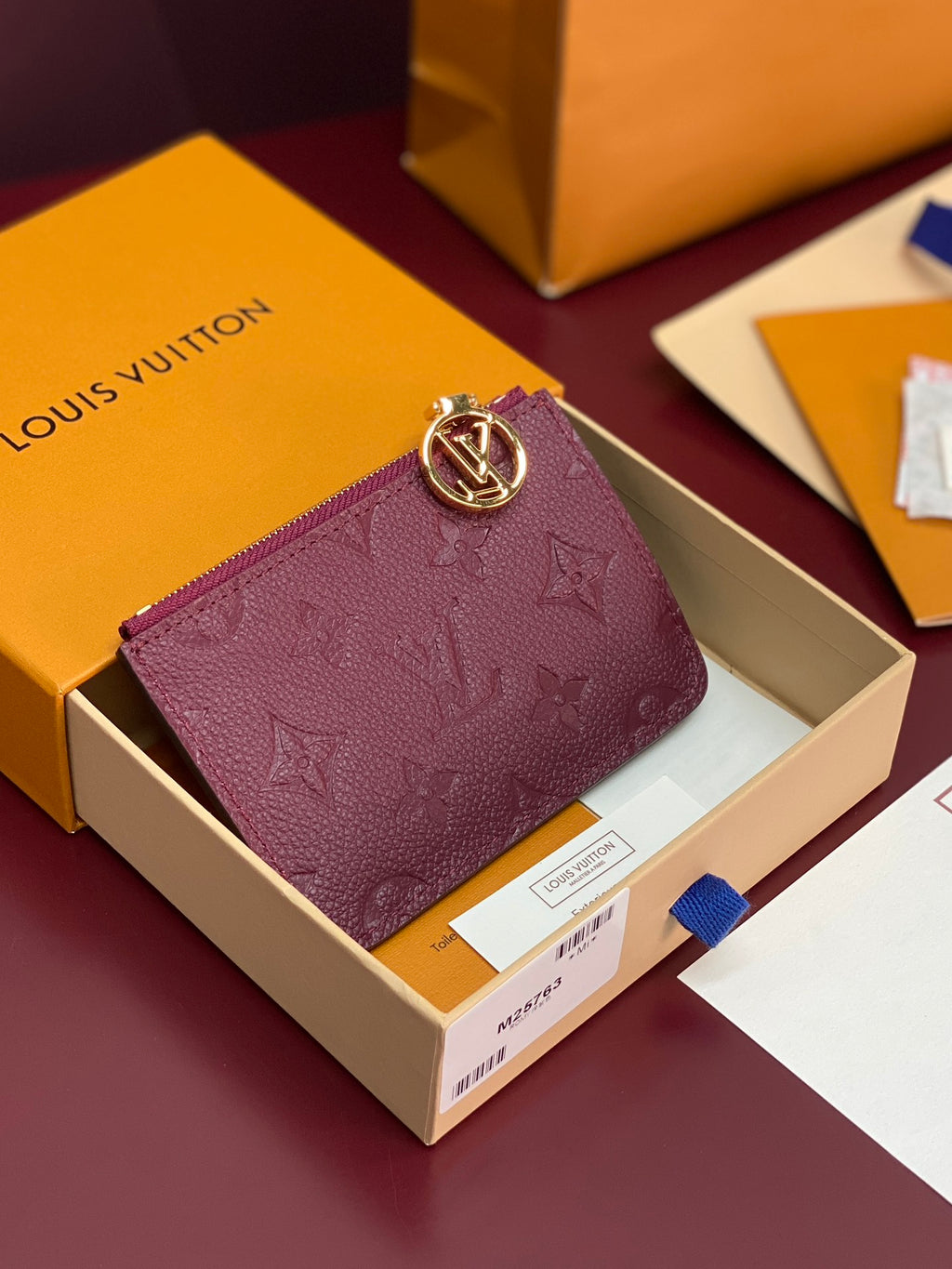 Small leather pouch bag in burgundy with monogram pattern and gold-tone clasp