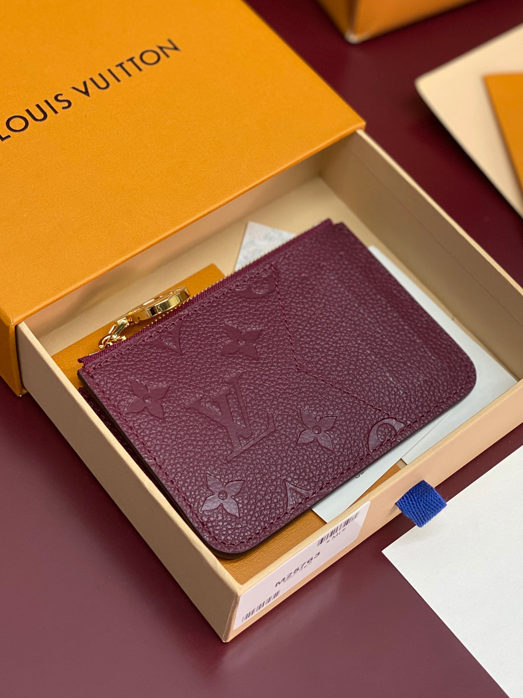 Small leather pouch bag with burgundy monogram and gold zipper pull