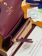 Small Louis Vuitton monogram bag with open top and gold zipper pull in dark plum leather